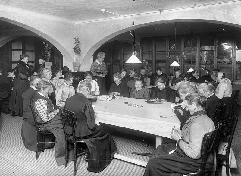 Kvinnor som handarbetar i lampsken.
© TT-nyhetsbyrån